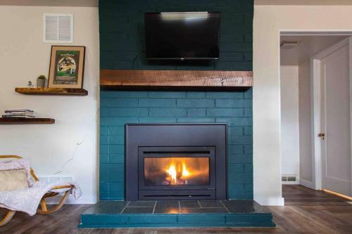 a blue brick fireplace with a television above it at Fireweed Gardens in Roger’s Park in Anchorage