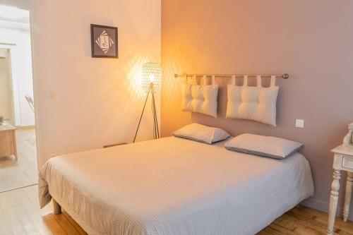 une chambre avec un grand lit avec deux oreillers dans l'établissement Chartres hyper centre bel appartement rénové, à Chartres