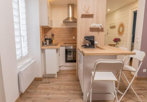 a kitchen with a counter and some chairs in it at Chartres hyper centre bel appartement rénové in Chartres
