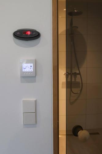 a bathroom with a shower with a clock on the wall at Pärnu Merimetsa Holiday Home in Pärnu