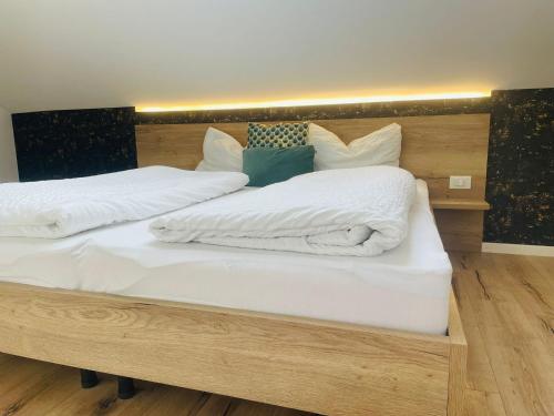 Duas camas com lençóis brancos e almofadas em Apartment Marie em Bolzano