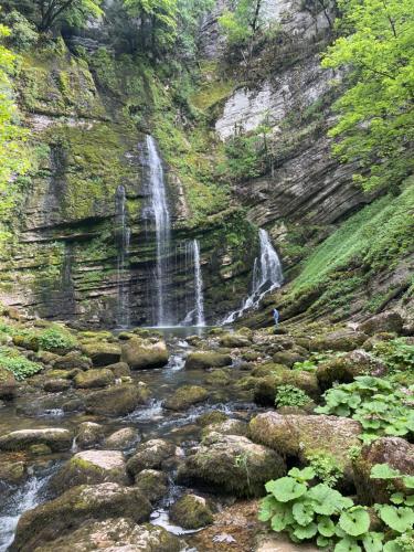 a waterfall on the side of a mountain with rocks at Confortable, au centre-ville in Saint-Claude