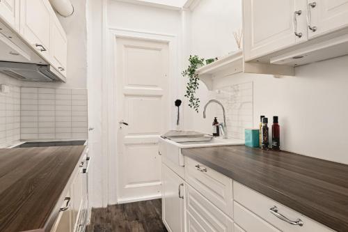 eine Küche mit weißen Schränken und einer hölzernen Arbeitsplatte in der Unterkunft Dinbnb Homes I Idyllically Located 4-Bedroom Home in Bergen