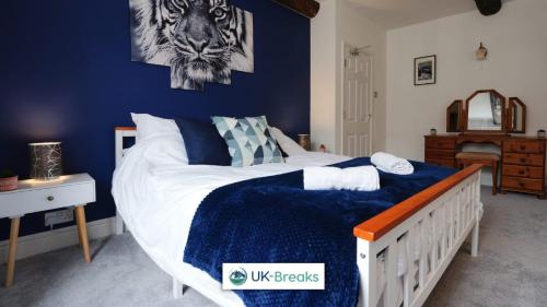 a bedroom with a bed with a blue wall at The historic Bulls Head-Grade II Listed in Chapel en le Frith