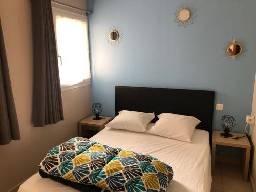 une chambre avec un lit avec une couette et une fenêtre dans l'établissement T2 Alba Rossa n 141 Confort, Panorama Mer Incroyable, à Serra-di-Ferro