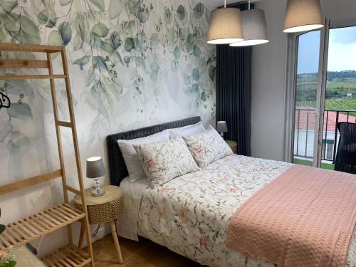 una camera da letto con un letto e carta da parati floreale di La Cigarrita Guest House a Vila Seca