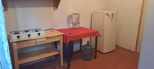 a small kitchen with a table and a refrigerator at Casa Deja-vu in San Marcos La Laguna
