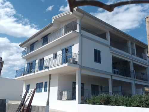 - un immeuble blanc avec balcon dans l'établissement Casa Vacanze il mirto, à Bari Sardo