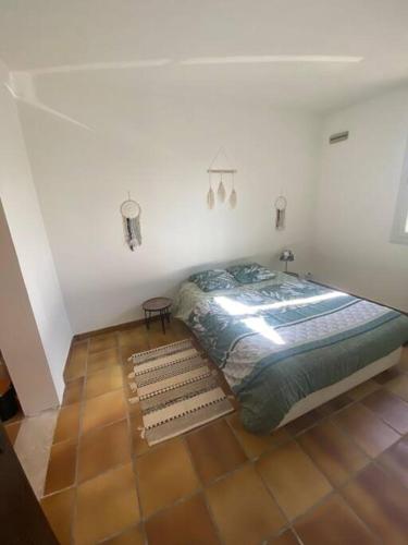 a bedroom with a bed and a tiled floor at L’échappée de Vallon in Vallon-Pont-dʼArc