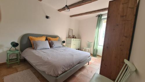 um quarto com uma cama e uma grande janela em Cocon du Papillon à Lourmarin em Lourmarin