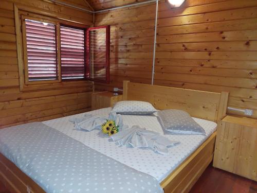 ein Schlafzimmer mit einem Bett in einer Holzhütte in der Unterkunft Pensiunea La Tavi in Murighiol