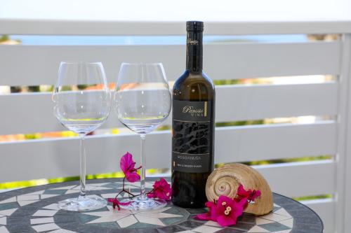 a bottle of wine and two glasses on a table at Stella Maris, Hvar - rooms with balcony and stunning sea views in Hvar