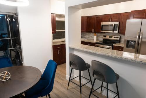 cocina con mesa, sillas y encimera en New Star Suite Two, en North Miami Beach
