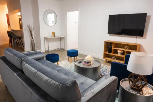 sala de estar con sofá y TV de pantalla plana en New Star Suite Two en North Miami Beach