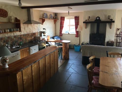 a kitchen with a counter and a table in it at Kate’s Cottage 