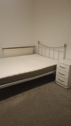 a bed sitting in a room with a dresser at Falcon Drive Room 1 in Oldham