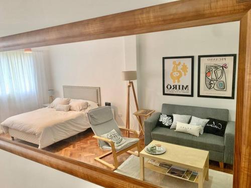 a reflection of a bedroom with a bed and a couch at flat in Buenos Aires in Buenos Aires