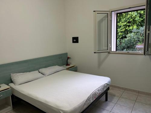 een wit bed in een kamer met een raam bij Villa Ialillo in Peschici