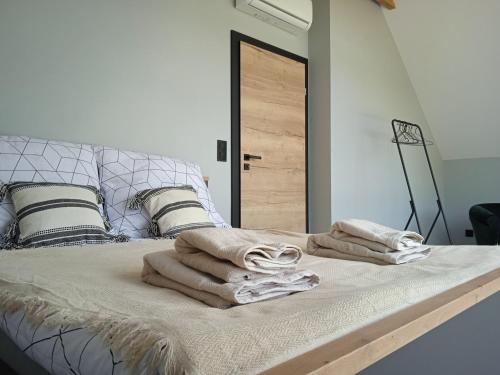 łóżko z dwoma ręcznikami na górze w obiekcie Lawendowa Stodoła w mieście AdamÃ³w