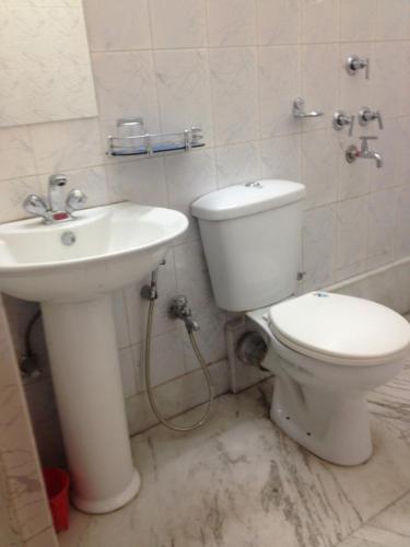 a bathroom with a toilet and a sink at Hotel Nest International in Kolkata