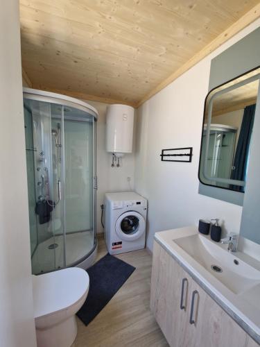 a bathroom with a shower and a sink and a toilet at Beach House Mane Sol - Perfect Seafront House For Relaxing Holidays in Drage