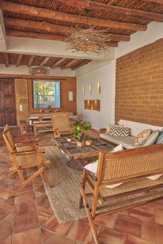sala de estar con sillas y pared de ladrillo en Casa Pumata Barichara en Barichara