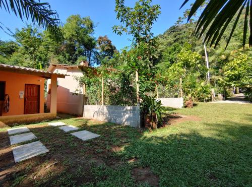 a yard with a house and a tree at Chalés Bela Vista in Paraty