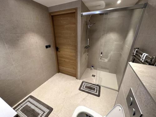 y baño con ducha, aseo y lavamanos. en Appartement de luxe, parking sous-terrain, centre-ville Auron, en Auron
