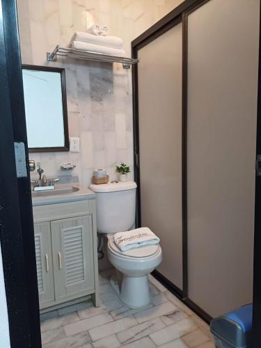 a bathroom with a toilet and a sink at Casa Las Palmas in Cancún