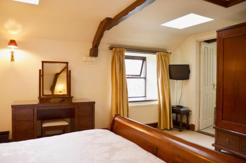 een slaapkamer met een bed, een spiegel en een dressoir bij Chestnut in Alston