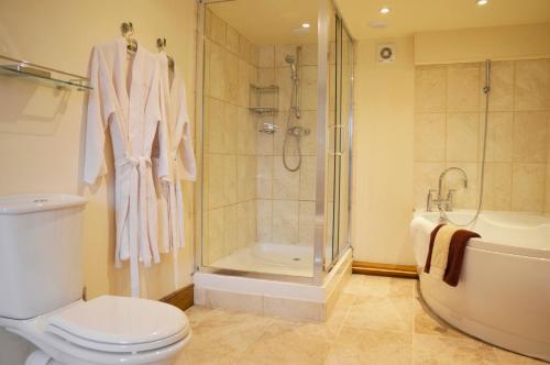 een badkamer met een douche, een toilet en een bad bij Chestnut in Alston
