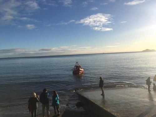 a boat in the water next to a group of people at KINGHORN - Private Room, own entrance, ensuite, sunroom & Views in Kinghorn