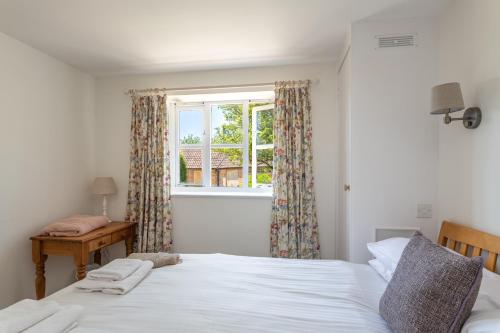 a bedroom with a bed and a window at The Dairy in Beaminster