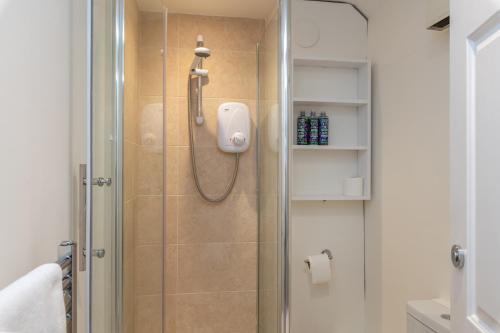a bathroom with a shower with a glass door at The Dairy in Beaminster