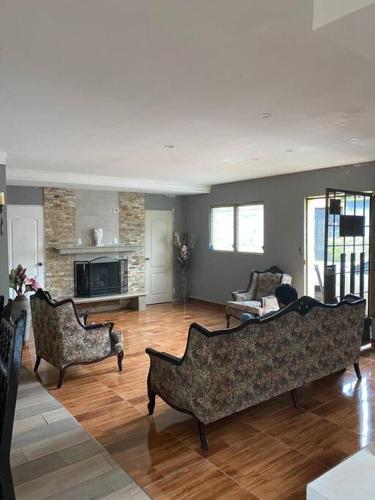 a living room with two couches and a fireplace at La casa de luz in Concepción de Ataco