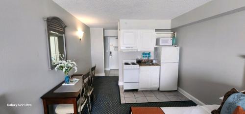 uma pequena cozinha com armários brancos e um frigorífico branco em Oceanfront Efficiency T508 em Myrtle Beach