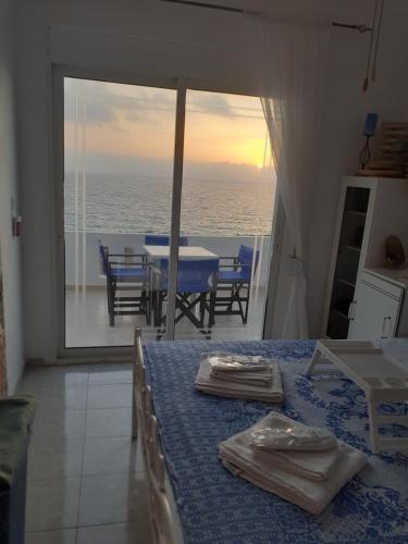 a room with a table and a view of the ocean at Seafront Aegean Νest in Karpathos Town