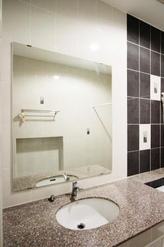 a bathroom with a sink and a mirror at Noppakao Place in Chiang Mai