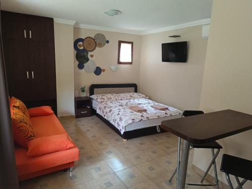 a bedroom with a bed and a table and a chair at Apampa Apartman in Hajdúszoboszló