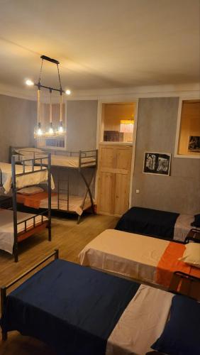 um quarto com três beliches e uma mesa em Orbeliani Hostel em Tbilisi