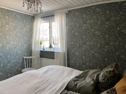 a bedroom with a large bed and a window at Sommarstuga med sjötomt och brygga in Hedemora
