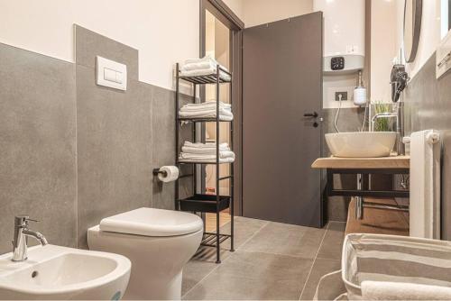 y baño con aseo blanco y lavamanos. en A 3 minuti dal centro storico In Style Apartment con parcheggio gratuito en Bassano del Grappa