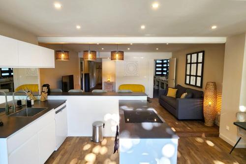 Pacific Suite في أغو: مطبخ وغرفة معيشة مع أريكة في الخلفية