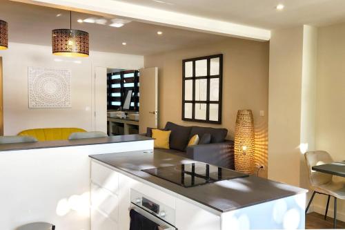 Pacific Suite في أغو: مطبخ وغرفة معيشة مع أريكة وطاولة