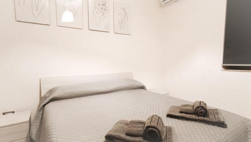 um quarto com uma cama com sapatos em Civico 5 em Bacu Abis