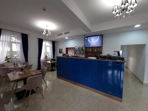 een restaurant met een blauwe bar met tafels en stoelen bij Mini Paradis in Oradea