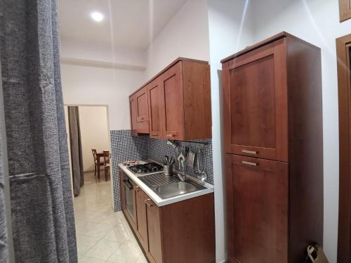 a small kitchen with wooden cabinets and a sink at Il Vico in Gaeta