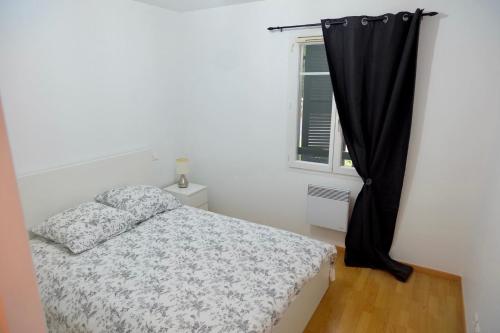 1 dormitorio con cama y ventana en Appartement dans résidence au calme, en Bayona