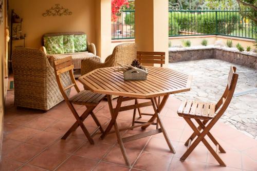 een houten tafel en stoelen op een patio bij Delizioso appartamento nel Golfo di Orosei con veranda in Cala Liberotto