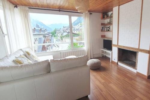 sala de estar con sofá blanco y ventana grande en Las vistas de Cerler, en Cerler